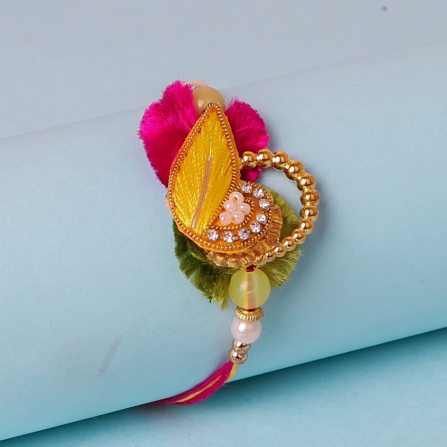 Gold leaf and pink flower bracelet with pearl, a unique rakhi with stone and design.