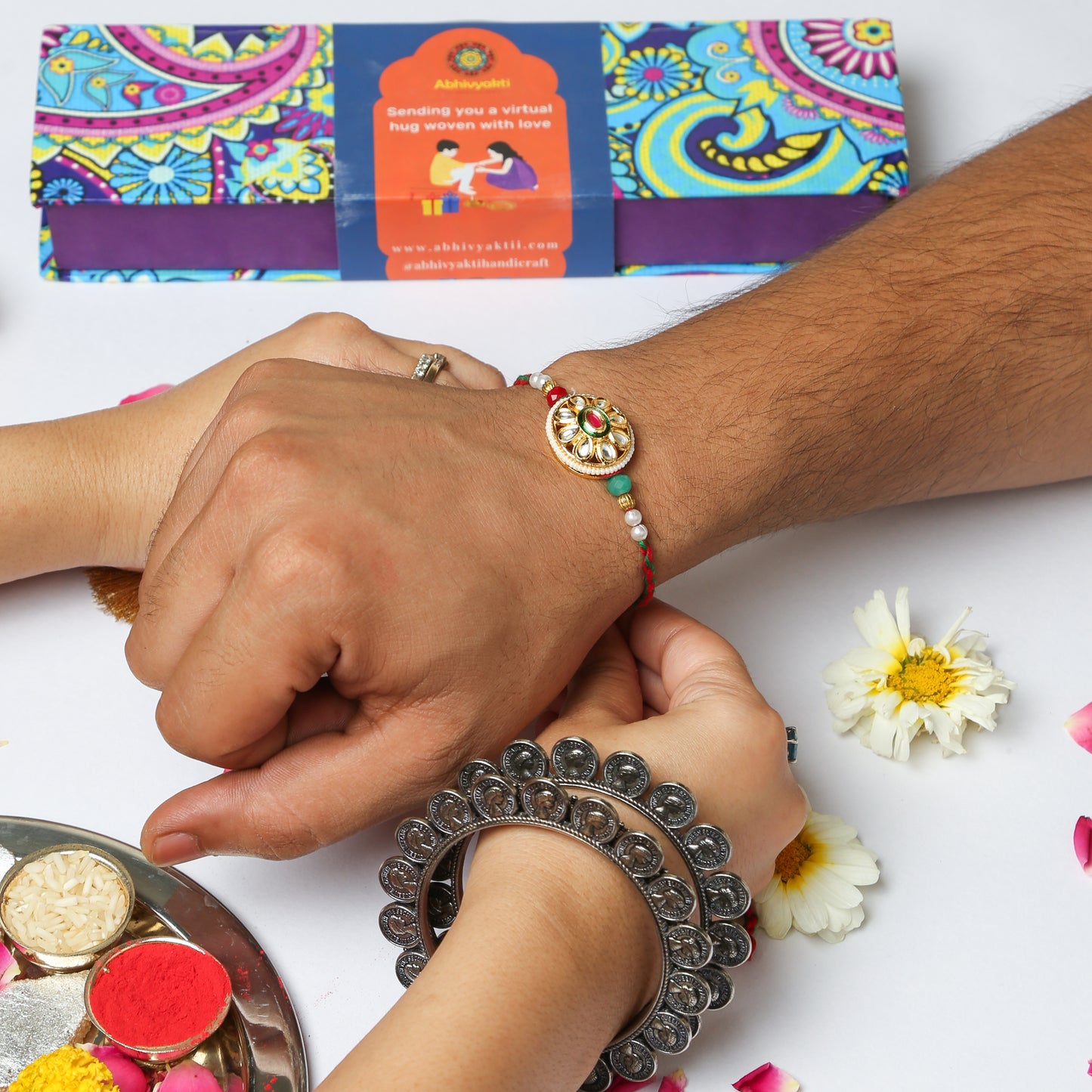 Sister tying an elegant stone rakhi to her brother and celebrating rakshabandhan in traditional Indian way