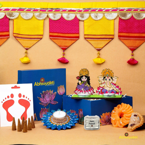 A festive Diwali hamper filled with an assortment of decorative items and treats. The hamper includes colorful floating diya, a box of mithai sweet candle, fragrant incense sticks, a small decorative toran, and festive Ganesh Lakshmi tealight alongwith tangy juicy mango roll up . The items are beautifully arranged in a festive box with vibrant, rich colors and intricate detailing, evoking the spirit of Diwali celebrations. The hamper is a perfect gift for the festive vibe