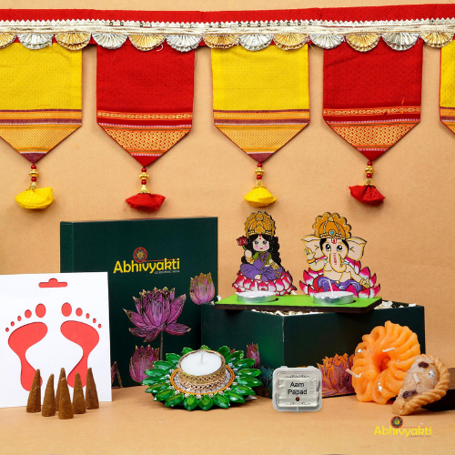 A festive Diwali hamper filled with an assortment of decorative items and treats. The hamper includes colorful floating diya, a box of mithai sweet candle, fragrant incense sticks, a small decorative toran, and festive Ganesh Lakshmi tealight alongwith tangy juicy mango roll up . The items are beautifully arranged in a festive box with vibrant, rich colors and intricate detailing, evoking the spirit of Diwali celebrations. The hamper is a perfect gift for the festive vibe