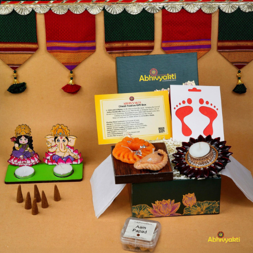 A festive Diwali hamper filled with an assortment of decorative items and treats. The hamper includes colorful floating diya, a box of mithai sweet candle, fragrant incense sticks, a small decorative toran, and festive Ganesh Lakshmi tealight alongwith tangy juicy mango roll up . The items are beautifully arranged in a festive box with vibrant, rich colors and intricate detailing, evoking the spirit of Diwali celebrations. The hamper is a perfect gift for the festive vibe