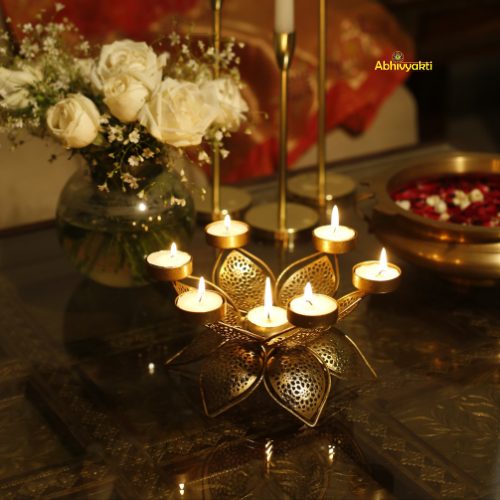 Decorative setup of Padam Tealight Holder Table Top (Large) with candles and flowers on a reflective surface