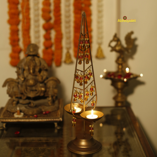 Decorative gold Kalp Taru with intricate designs on a reflective surface