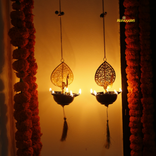 Decorative Peacock Swagata long chain T-light holder with lights against a sunset background