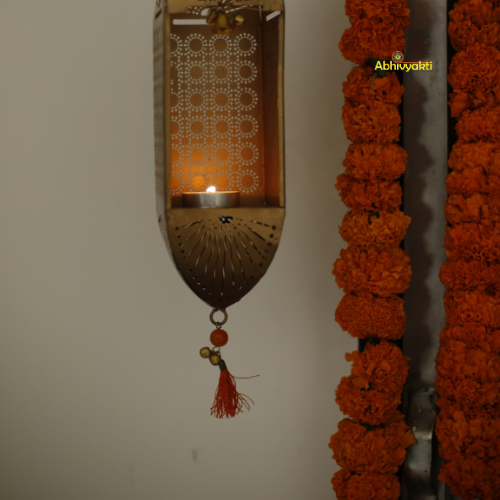 Decorative Traditional Mandir Hanging Tealight Holder with floral garland on a plain background