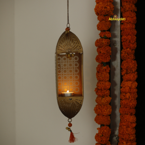Decorative marigold garlands and a Traditional Mandir Hanging Tealight Holder on a white wall.