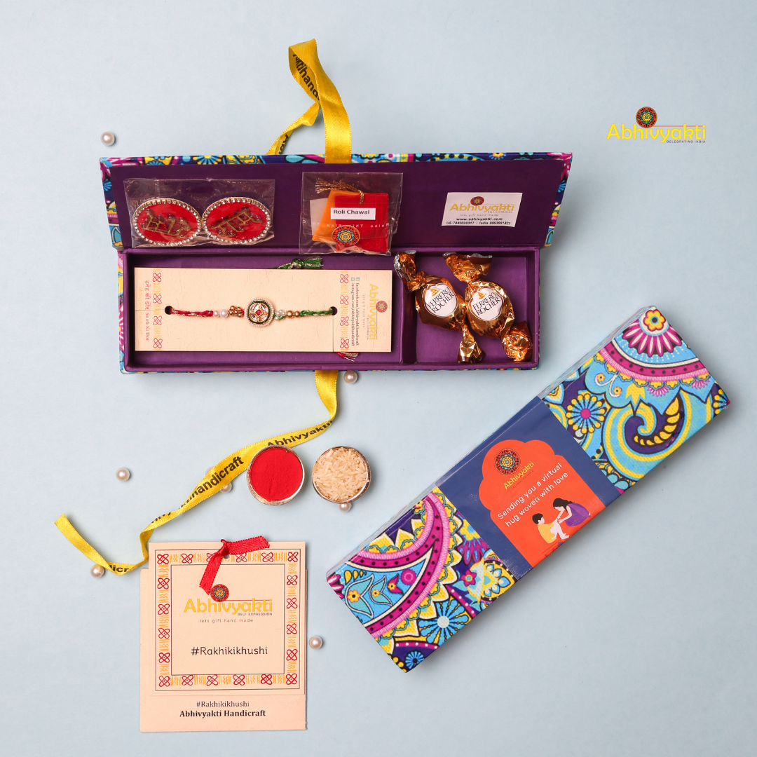 A traditional Rakhi featuring a central round design with red and green accents, surrounded by small pearls, intricate golden embellishments, and stone beads. The thread is braided in red and green, symbolizing the festival of Raksha Bandhan.