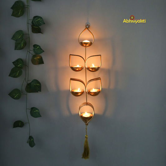 Tulsi - Wall Hanging Tealight Holder and orange beaded floral toran on a beige, gray background