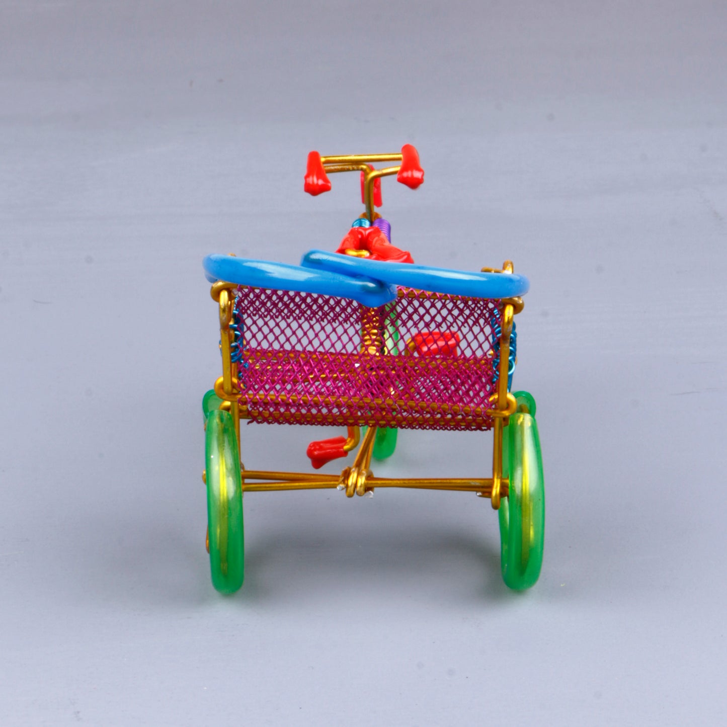 A handmade wire rickshaw decor piece crafted with intricate detailing. The wire frame captures the sleek and dynamic shape of a rickshaw, showcasing fine craftsmanship. Perfect for home decor or as a unique gift for kids