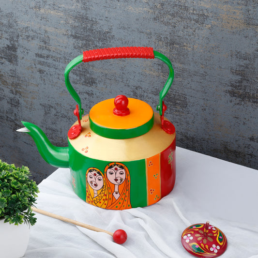 "A vibrant, handpainted kettle with quirky designs and bold colors, featuring intricate Indian folk art. The kettle is adorned with playful motifs and patterns, perfect as a decorative statement piece for a creative and culturally inspired home."