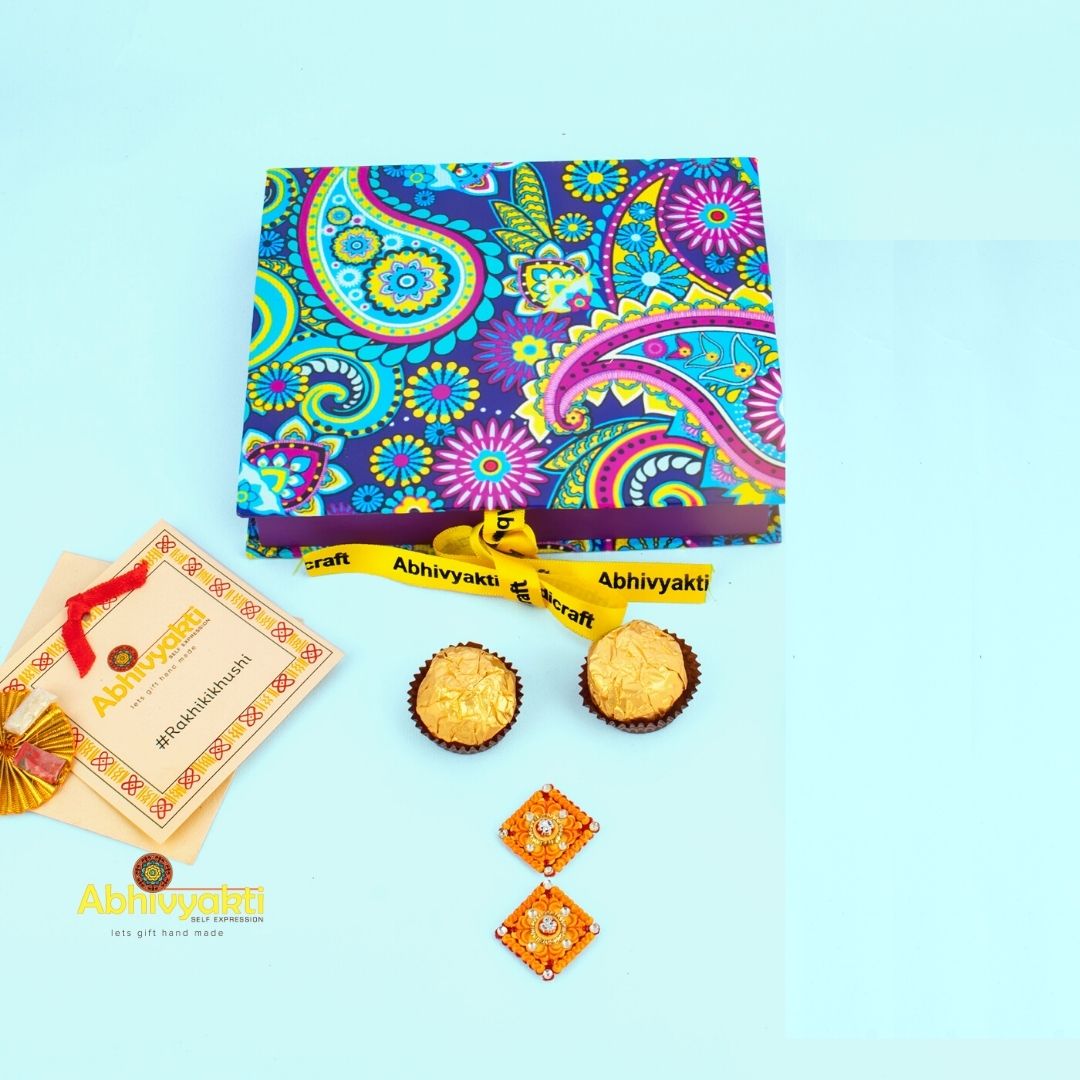 Red and white rakhi, each showcasing a special paisley lumba design with intricate stone and bead decorations, arranged on a plate.