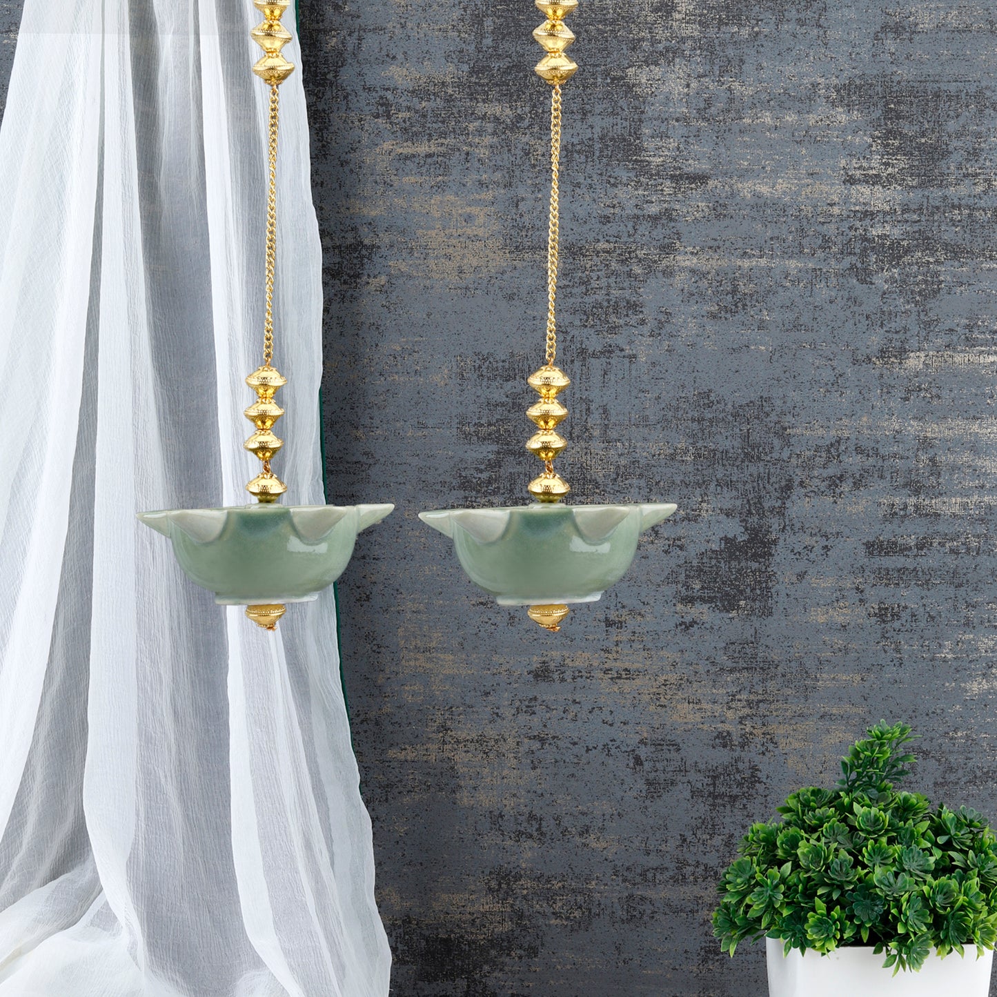 "Elegant wall-mounted Diwali diyas with intricate metal holders, designed to hang on the wall for a unique and stylish look. The diyas cast a soft, flickering light, creating a serene and festive ambiance for Diwali celebrations."