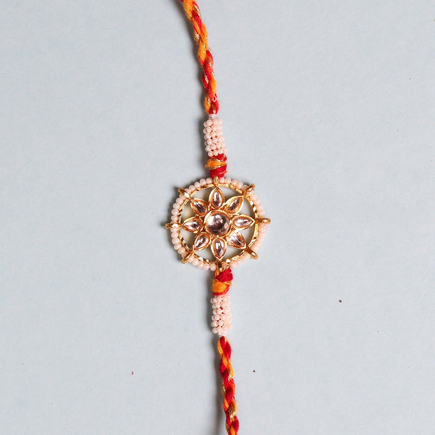 Rakhi bracelet from India featuring pearls and a special stone in wheel design