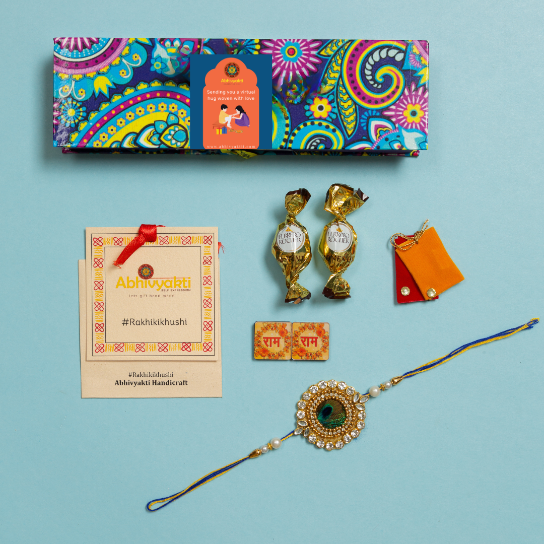 A colorful peacock feather centre rakhi with a gold and blue bead, packed in a beautiful hamper premium quality box