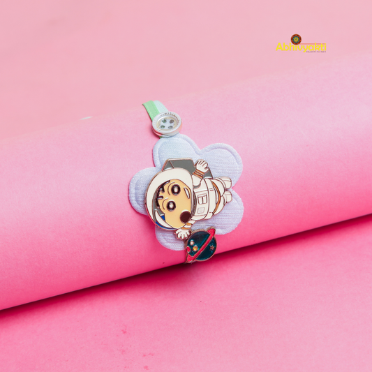 Vibrant Baby Astronaut Rakhi bracelet for kids, featuring a cute cartoon astronaut and spaceship charm on a pastel green thread, displayed on a Pink background 