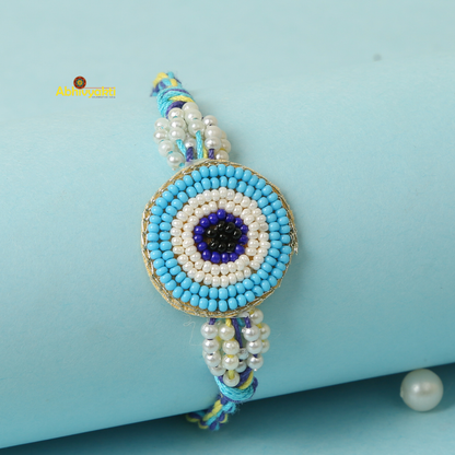 Stunning rakhi adorned with Sky blue and white beads and a blue eye charm.