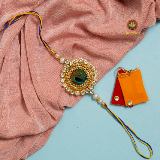 A colorful peacock feather centre rakhi with a gold and blue bead, premium quality.