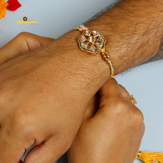 A vibrant Premium Rakhi embellished with stones, showcasing a yellow and red thread for festive celebrations