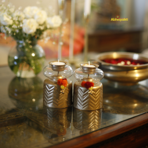 Decorative Anuya Tealight Holder Pair with gold accents on a reflective surface