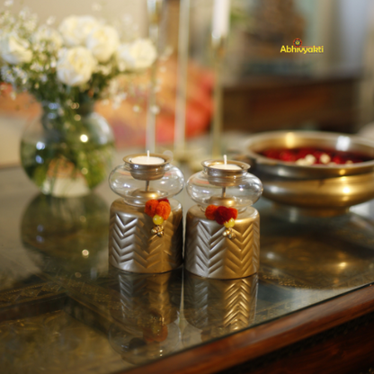 Decorative Anuya Tealight Holder Pair with gold accents on a reflective surface