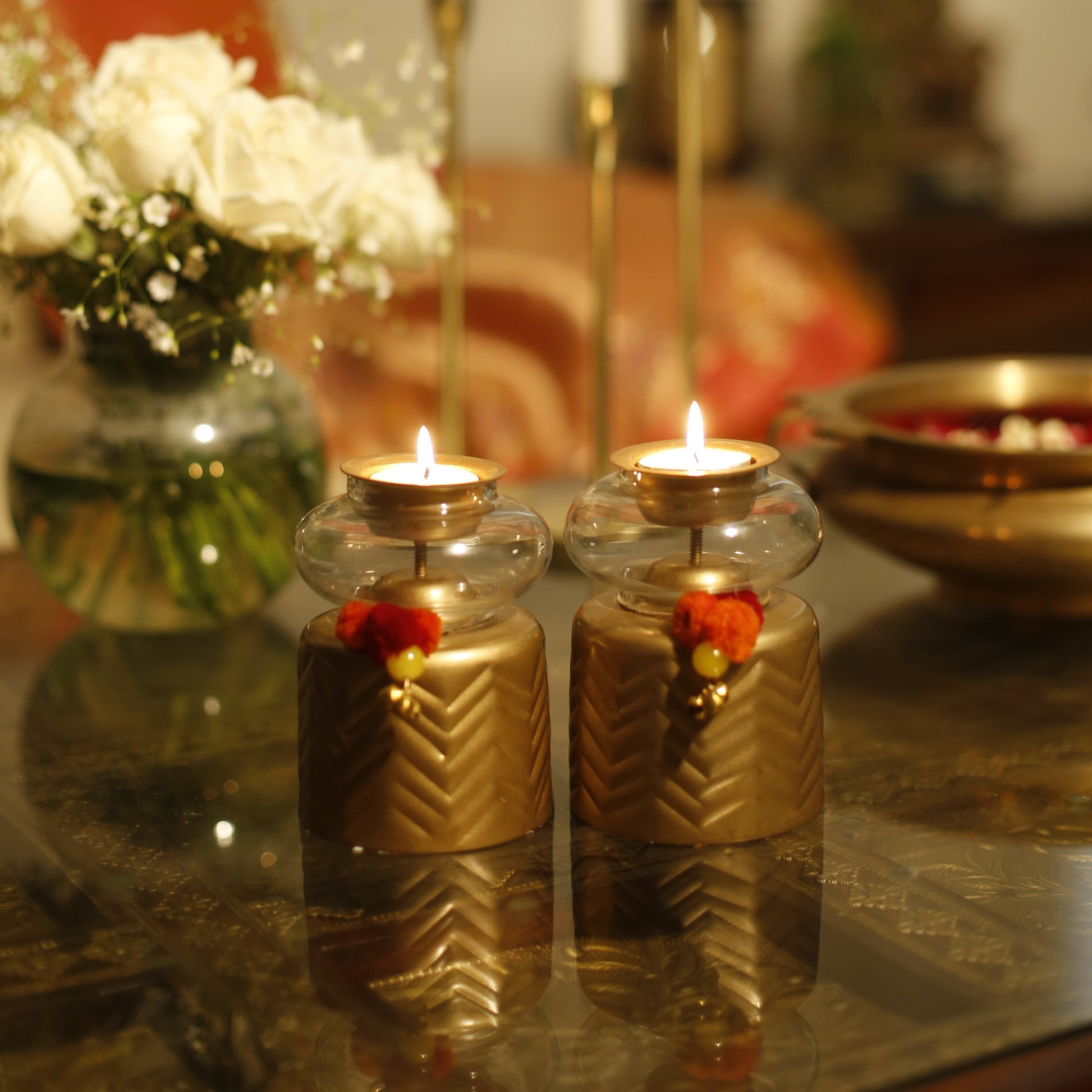 Close-up of Anuya Tealight Holder Pair with tealight on a reflective surface
