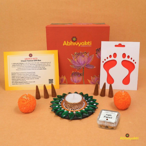 A festive Diwali hamper filled with an assortment of decorative items and treats. The hamper includes colorful floating diya, a box of mithai sweet candle, fragrant incense sticks, a small decorative toran, and festive Ganesh Lakshmi tealight alongwith tangy juicy mango roll up . The items are beautifully arranged in a festive box with vibrant, rich colors and intricate detailing, evoking the spirit of Diwali celebrations. The hamper is a perfect gift for the festive vibe