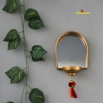 Decorative mirror tealight holder for Diwali decor with leaf garlands on a plain background