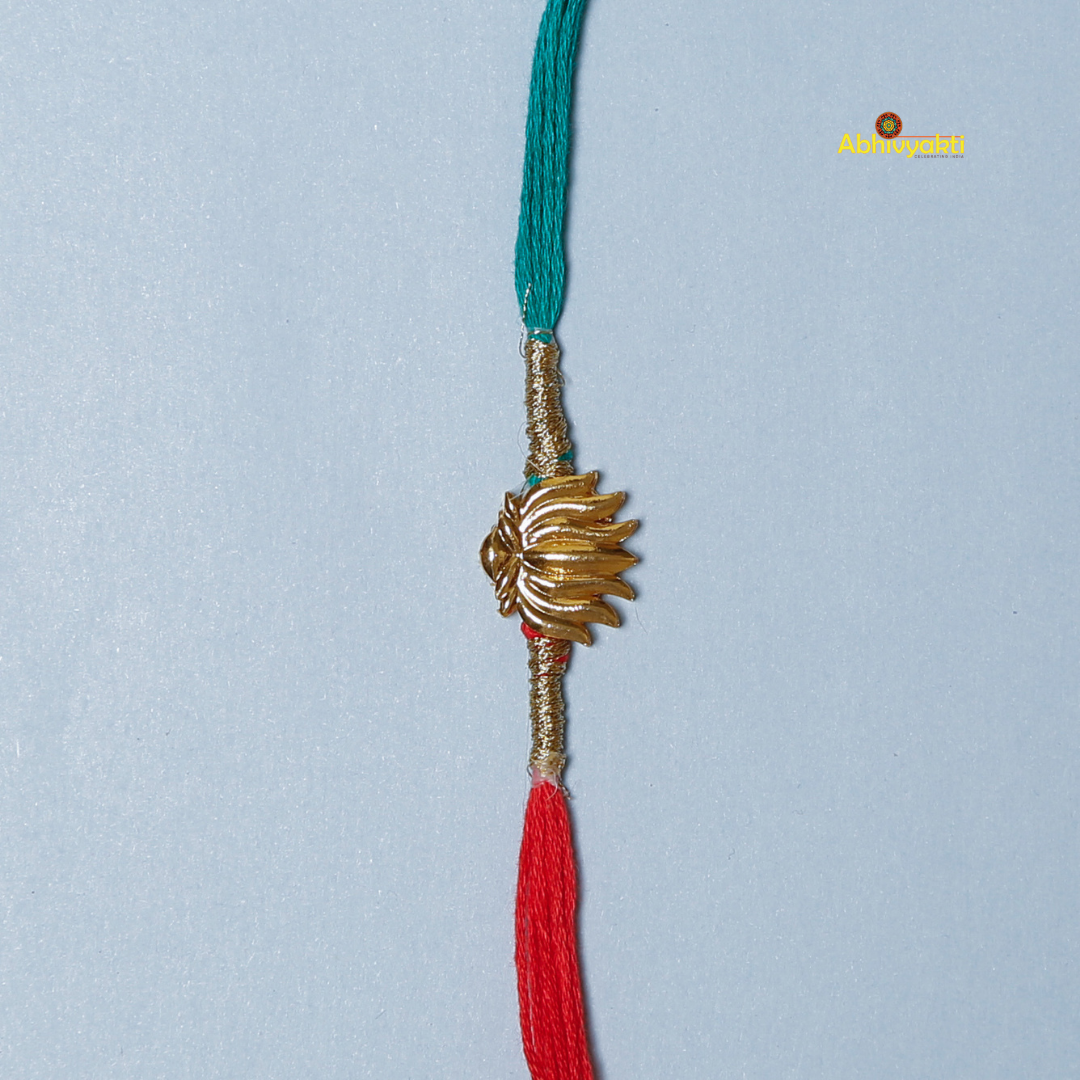 Elegant Rakhi featuring a golden lotus charm at the center, tied with contrasting red and teal threads. A minimal yet traditional design, perfect for celebrating Raksha Bandhan with a touch of symbolism and style