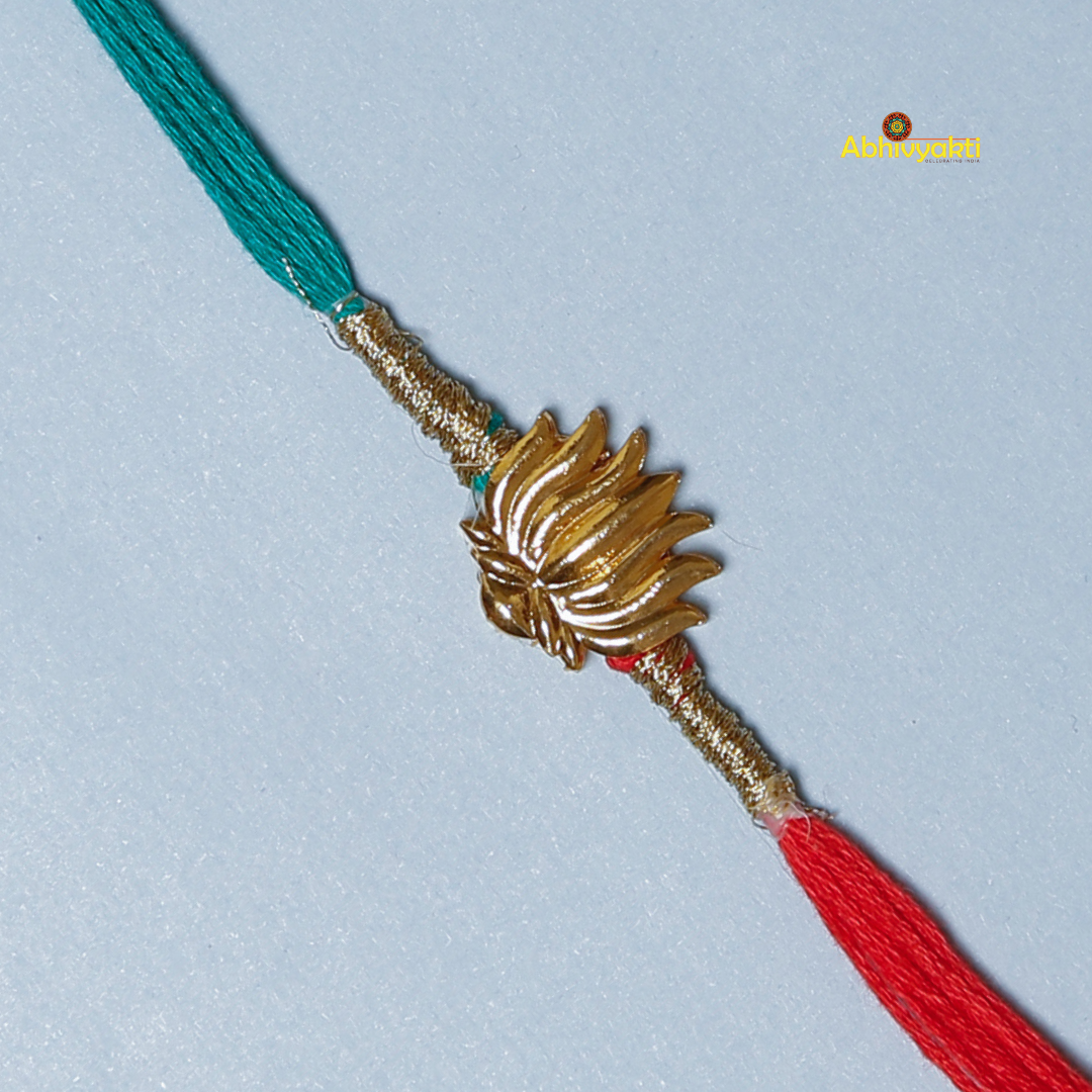 Elegant Rakhi featuring a golden lotus charm at the center, tied with contrasting red and teal threads. A minimal yet traditional design, perfect for celebrating Raksha Bandhan with a touch of symbolism and style
