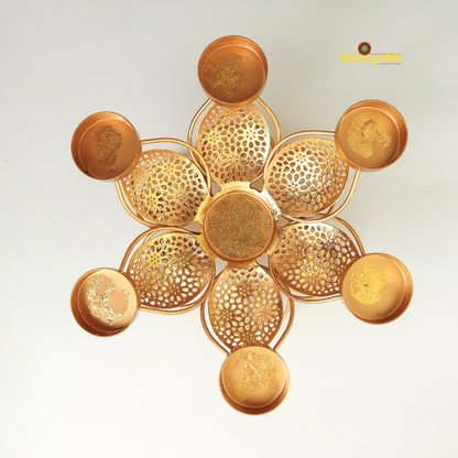 Golden metal padam t-light holder in a flower shape with six intricate perforated petals, each petal holding a small round cup for candles, placed on a white background