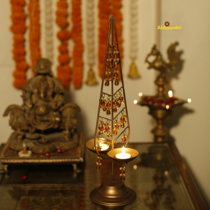 Decorative gold Kalp Taru with intricate designs on a reflective surface
