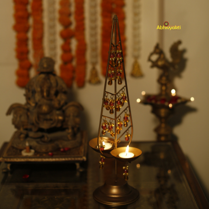 Decorative Kalp Taru tealight holder gold lamp with intricate design on a reflective surface.