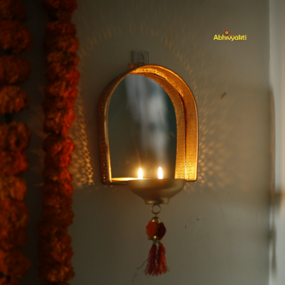 Decorative mirror tealight holder for Diwali decor with floral garlands on a plain background