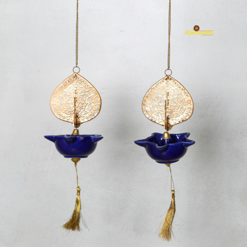 Two hanging decorative Peacock Swagata with blue bowls and gold leaf designs on a light gray background