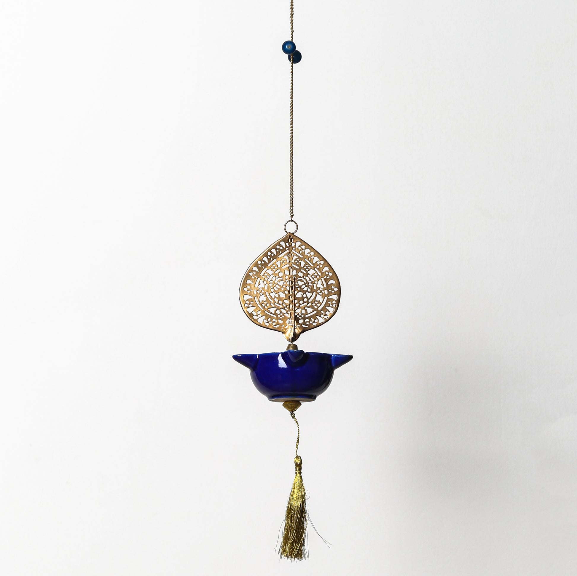 Decorative hanging ornament Peacock Swagata with blue bowl and gold filigree on a white background