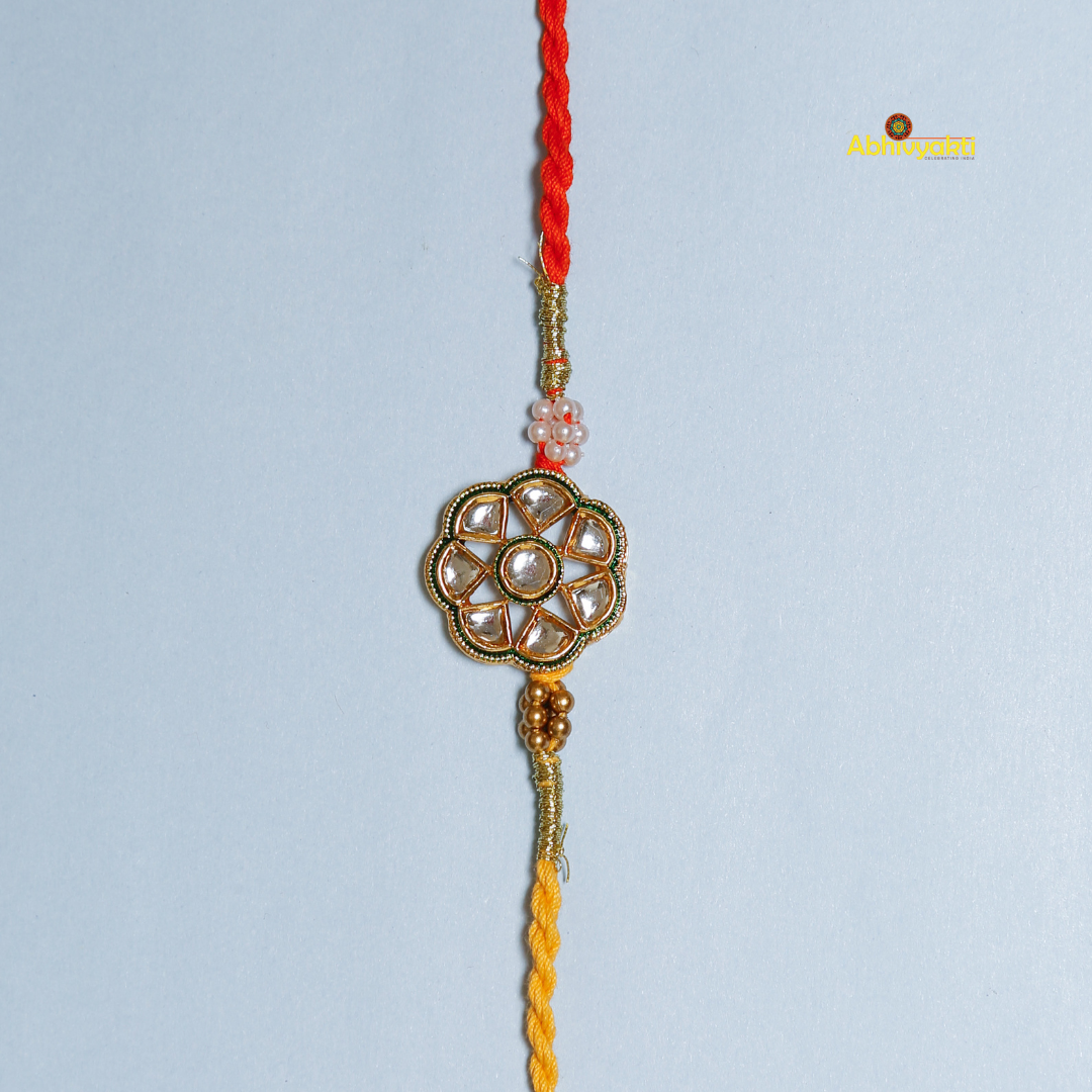 A vibrant Premium Rakhi embellished with stones, showcasing a yellow and red thread for festive celebrations