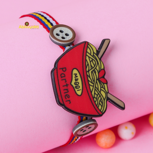 Quirky Rakhi featuring a red bowl of noodles with “Maggi Partner” text, paired with multicolored thread and cute button accents — perfect for celebrating sibling bonds with a fun, foodie twist.