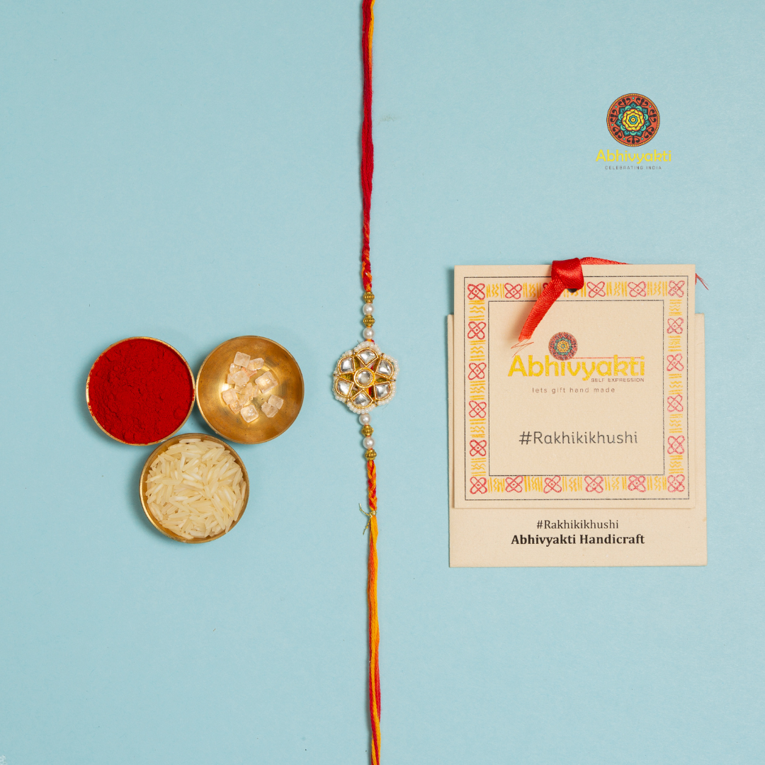 Red and gold kundan rakhi with pearls and beads, embellished with stones and beads.