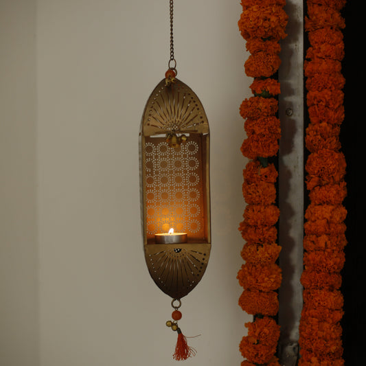 Decorative marigold garlands and a Traditional Mandir Hanging Tealight Holder on a white wall.