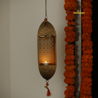 Decorative marigold garlands and a Traditional Mandir Hanging Tealight Holder on a white wall.