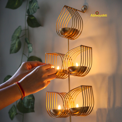 Tulsi - Wall Hanging Tealight Holder and orange beaded floral toran on a beige, gray background