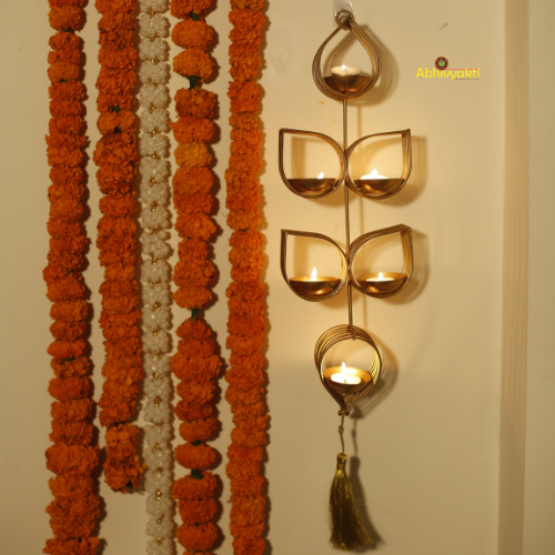 Tulsi - Wall Hanging Tealight Holder and orange beaded floral toran on a beige background