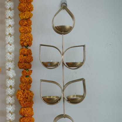 Decorative Tulsi tealight holder with orange and white flowers and a decorative metal piece on a white background