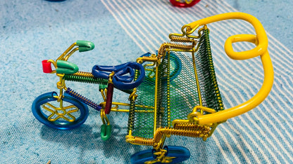 A handmade wire rickshaw decor piece crafted with intricate detailing. The wire frame captures the sleek and dynamic shape of a rickshaw, showcasing fine craftsmanship. Perfect for home decor or as a unique gift for kids