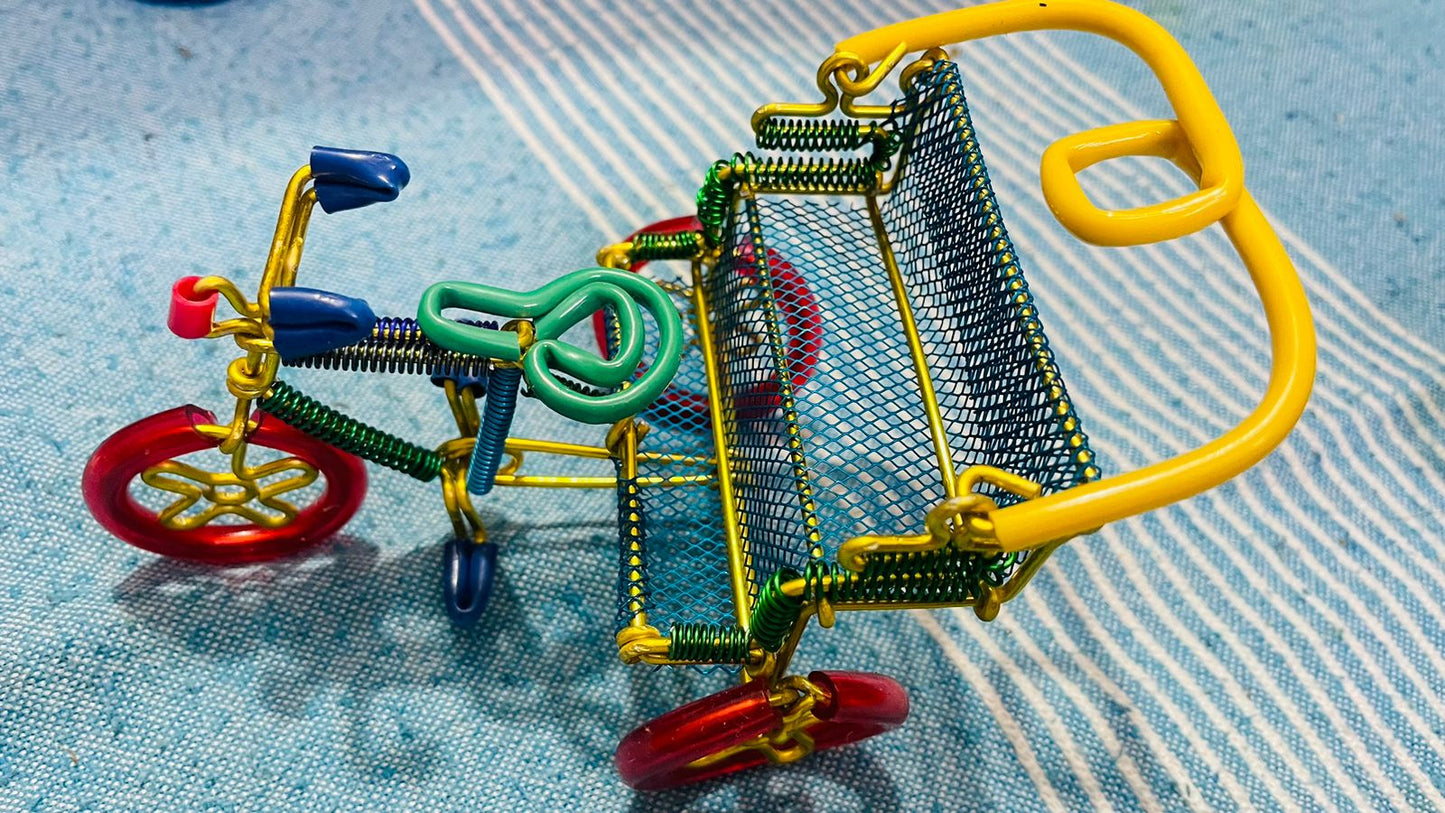 A handmade wire rickshaw decor piece crafted with intricate detailing. The wire frame captures the sleek and dynamic shape of a rickshaw, showcasing fine craftsmanship. Perfect for home decor or as a unique gift for kids