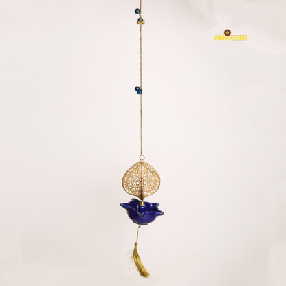 Decorative hanging peacock swagata diya with blue lotus design and gold accents on a white background