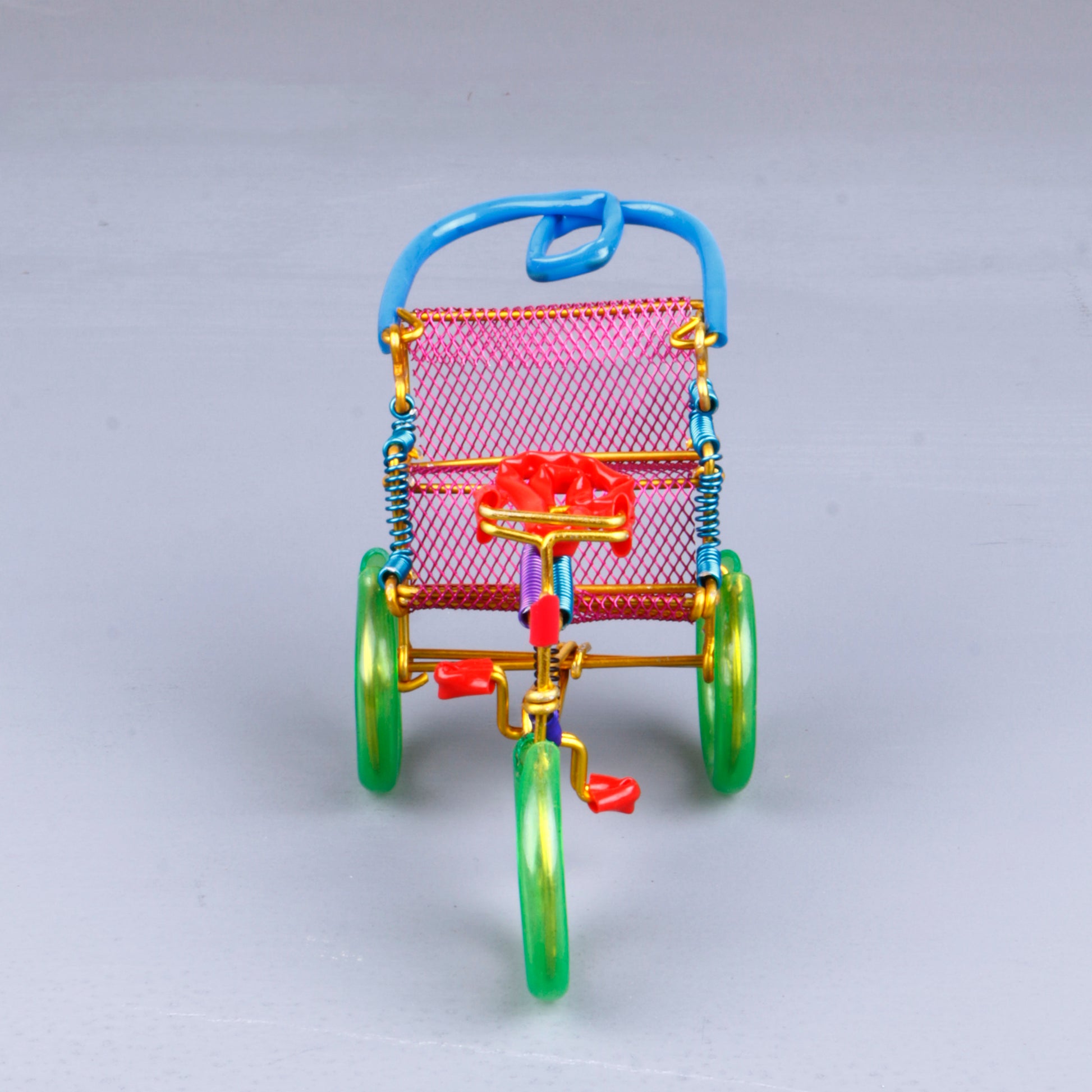 A handmade wire rickshaw decor piece crafted with intricate detailing. The wire frame captures the sleek and dynamic shape of a rickshaw, showcasing fine craftsmanship. Perfect for home decor or as a unique gift for kids