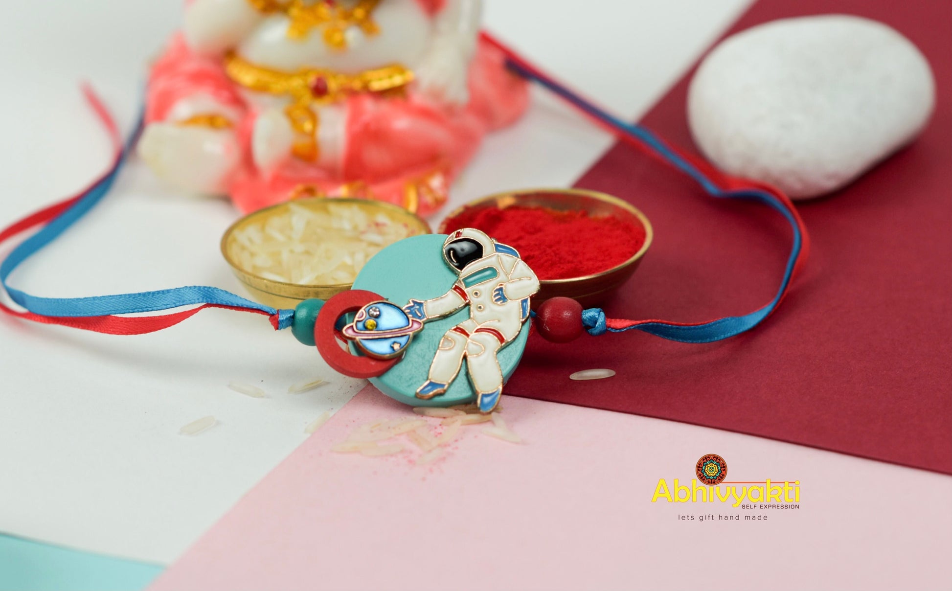 Beautiful kids rakhi adorned with beads and a small figurine with a button.
