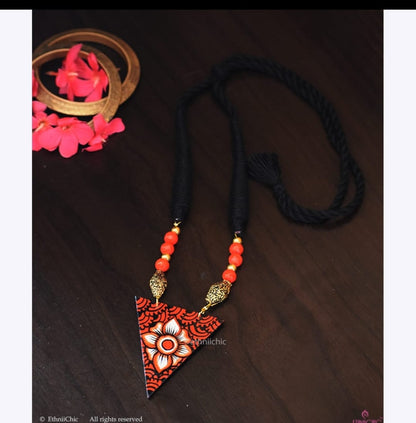 This beautiful necklace is hand painted and an exquisite Indian Jewellery inspired by Kerala Mural Art designed on crafted wood. It is surely an elegant wear for any occasion. A perfect head turner and a conversation starter..